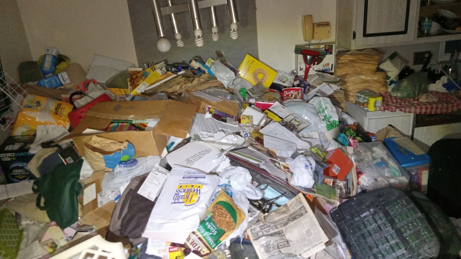 Before: the same kitchen buried in bags, boxes and paper